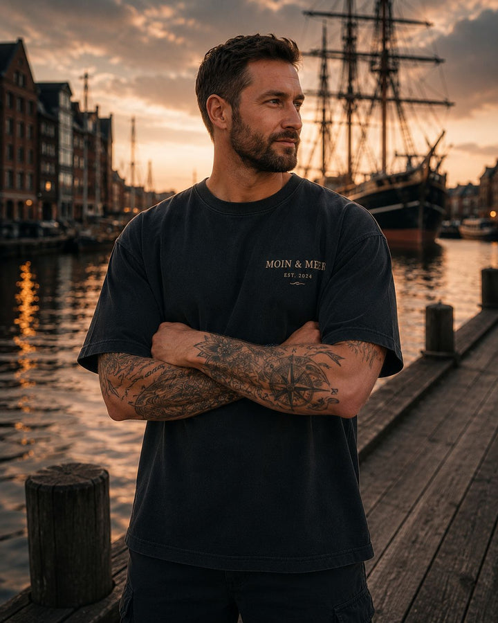 Herren T-Shirt Moin und Meer Est 2024 washed schwarz Brustlogo Oversized Fit am Elsflether Hafen Sonnenuntergang